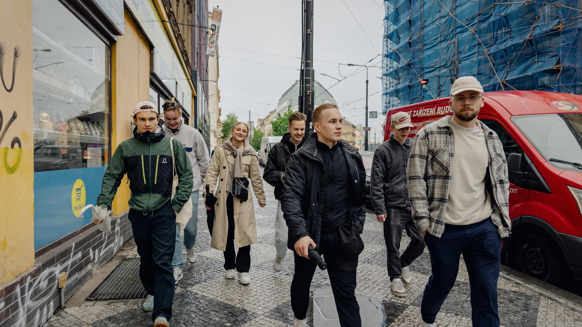 Ropinan porukka kävelee Prahan kadulla sateen jälkeen